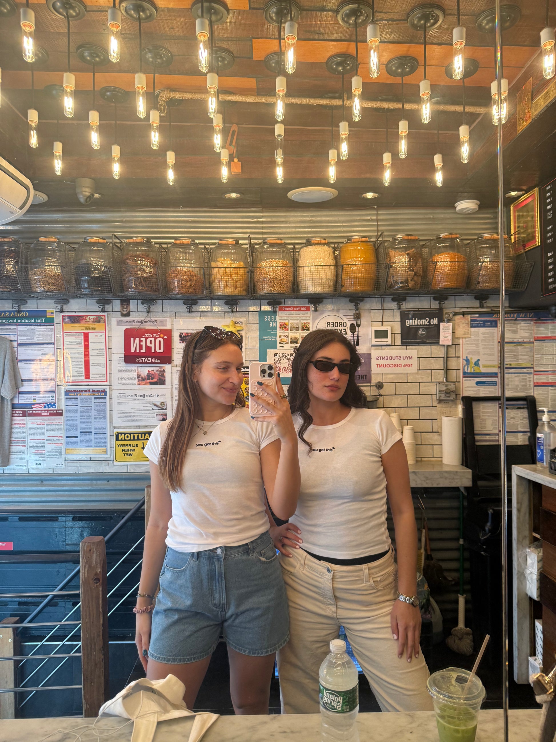 two girls wearing white affirmation baby tee you got this mirror selfie diner cafe lifestyle confidence