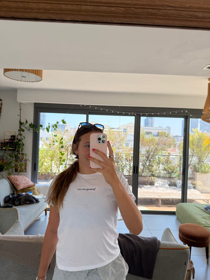 woman wearing white affirmation t-shirt you are glowing mirror selfie casual style indoors