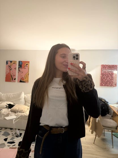 woman wearing white affirmation t-shirt you look good mirror selfie layered jacket outfit living room